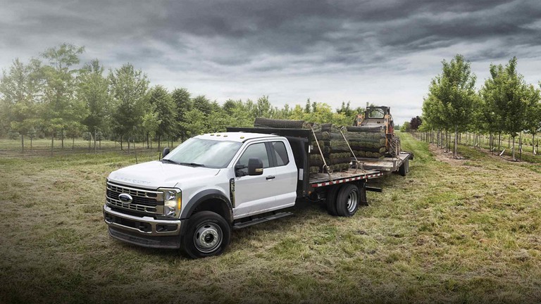 Ford Super Duty® F-350 2025 chargé de gazon et tirant une remorque avec un Bobcat