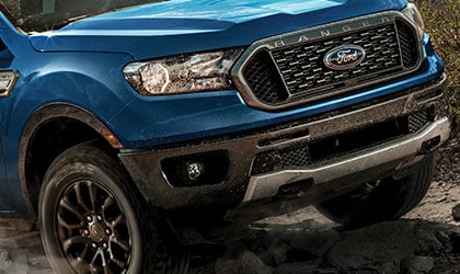 Ford Ranger 2020 en bleu foudre sur des rochers près de montagnes