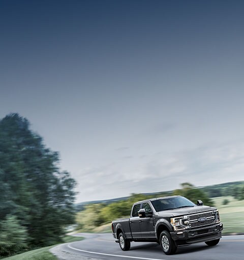 Super Duty sur une autoroute bordée d'arbres. Offre illustrée.