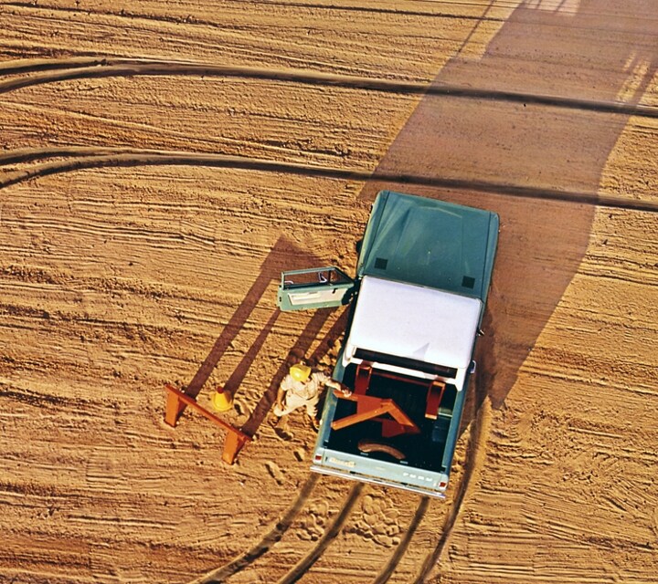 Un homme déchargeant du bois de l’arrière d’un camion Ford Bronco 1969 vert lunaire