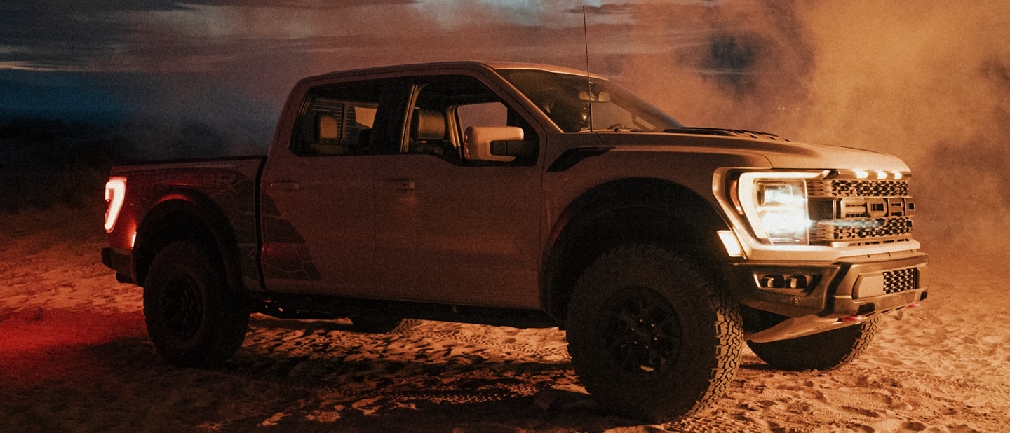 Un Ford F 150 Raptor R 2023 sur le sable au crépuscule
