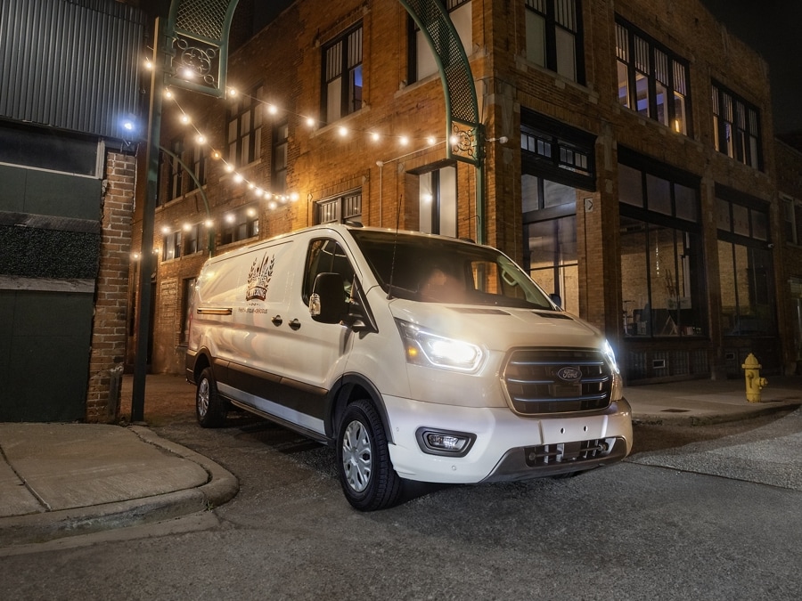 Un Ford E-Transit™ 2026 sortant d'une ruelle entre deux immeubles