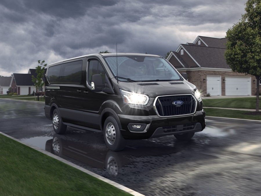 Une fourgonnette utilitaire Ford Transit sur une route de banlieue.
