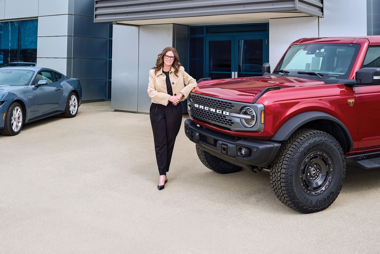 Personne s’appuyant sur un Bronco chez un concessionnaire Ford.