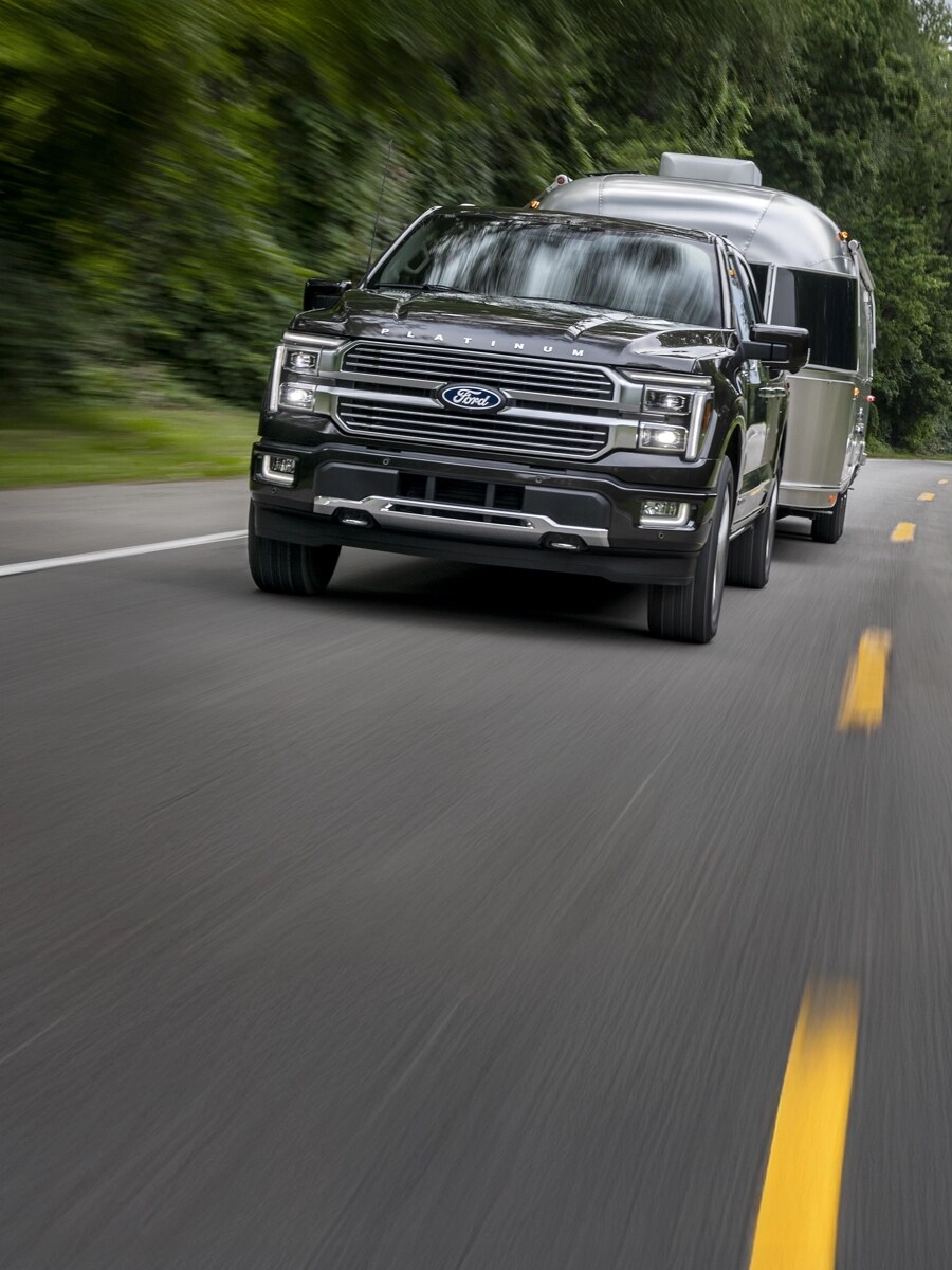 F 150 tractant une remorque sur une autoroute à deux voies.