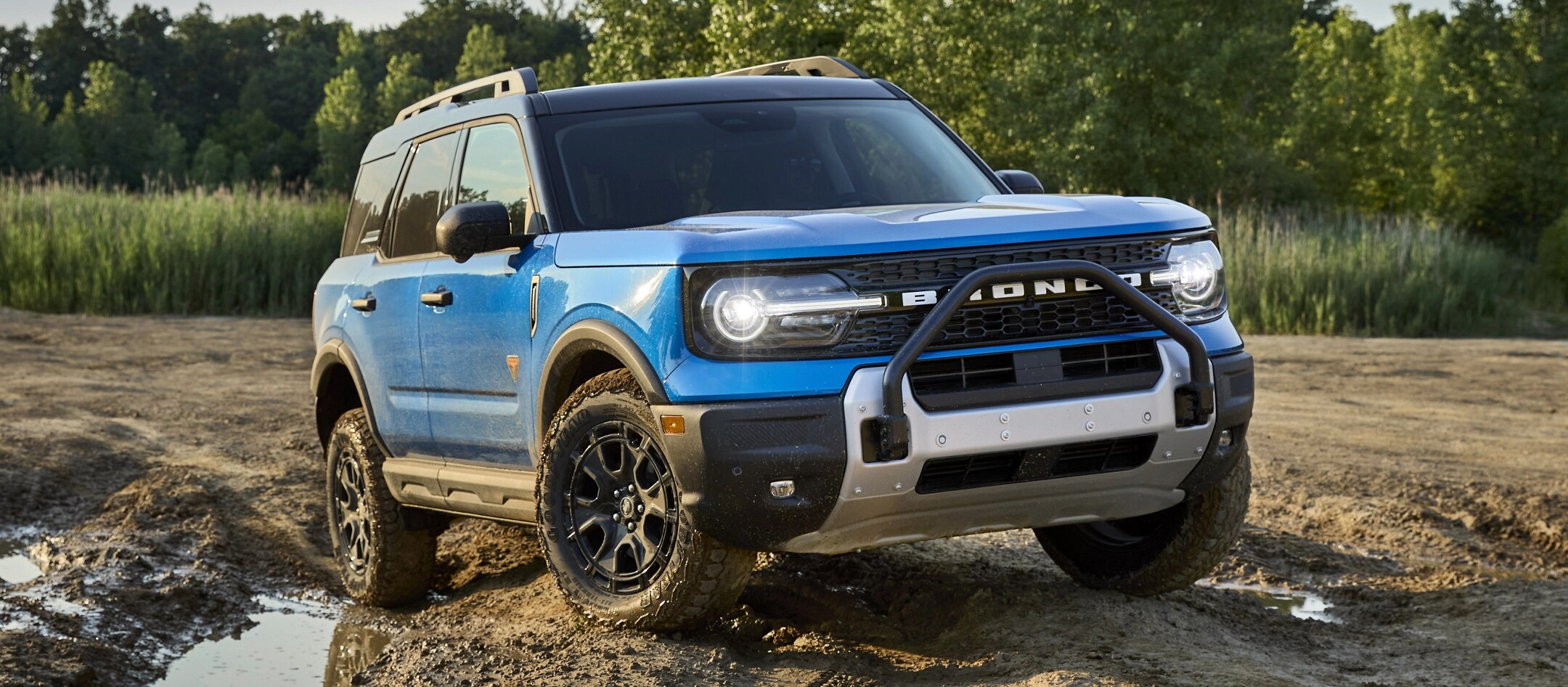 Ford Bronco Sport® 2025 conduit dans la terre et près d’une flaque de boue