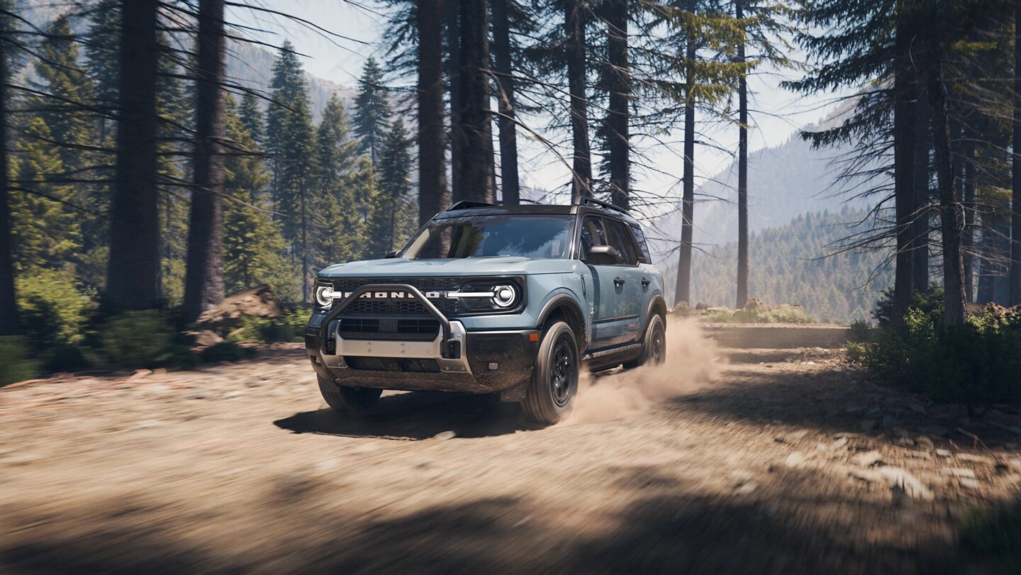 Ford Bronco Sport® 2025 conduit sur un chemin de terre avec des arbres de chaque côté