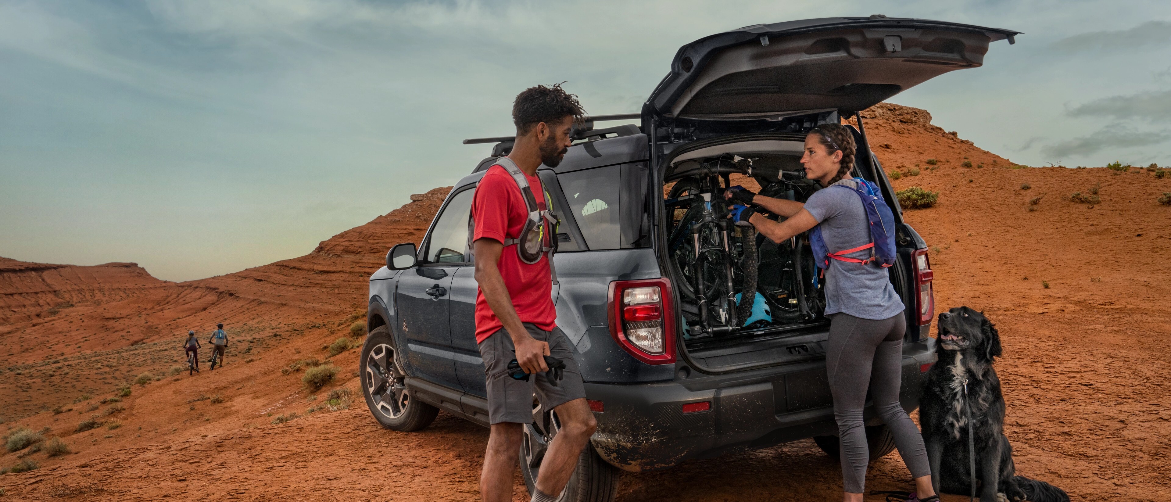 Ford Bronco Sport® 2025 avec le toit arrière ouvert et deux personnes debout à l'extérieur du véhicule