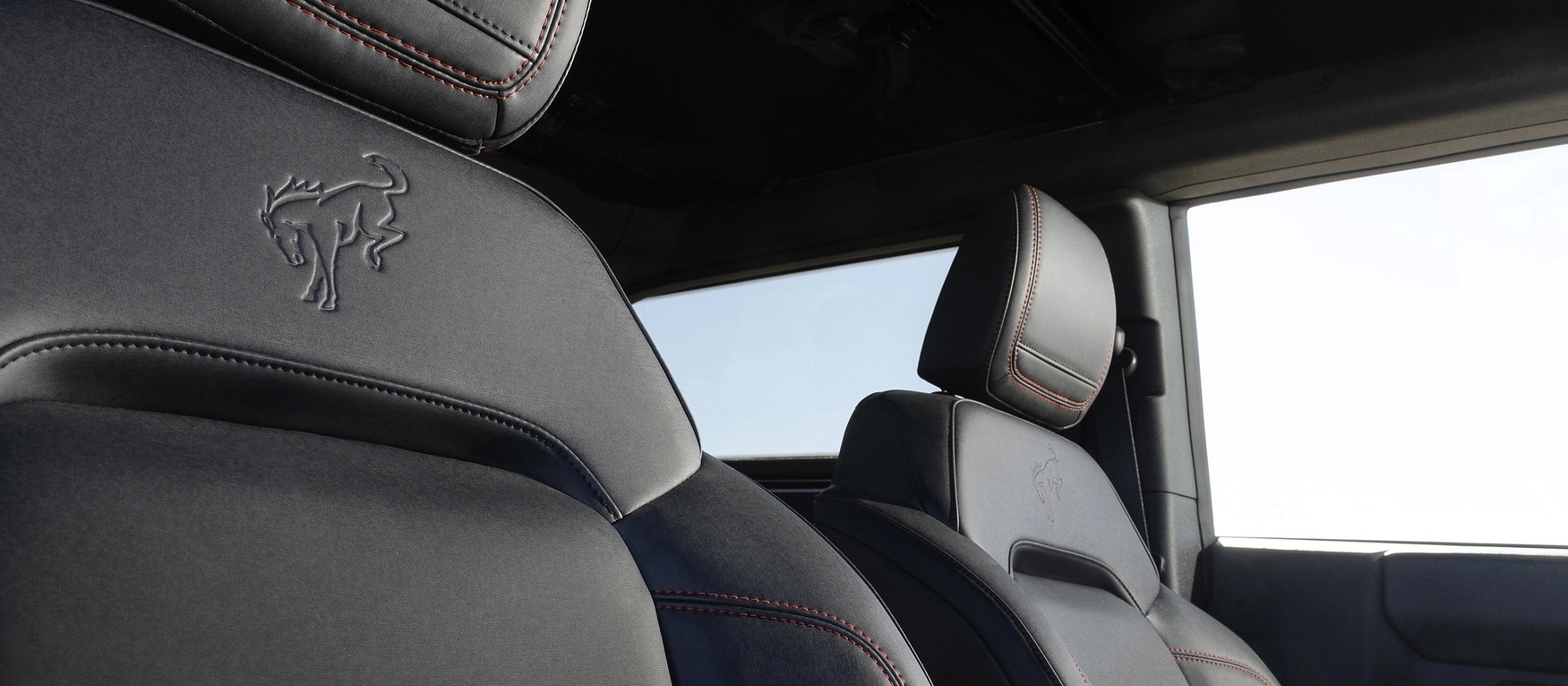 Gros plan de l'emblème en relief sur le revêtement des sièges avant d'un VUS Ford Bronco® Stroppe Edition 2025.