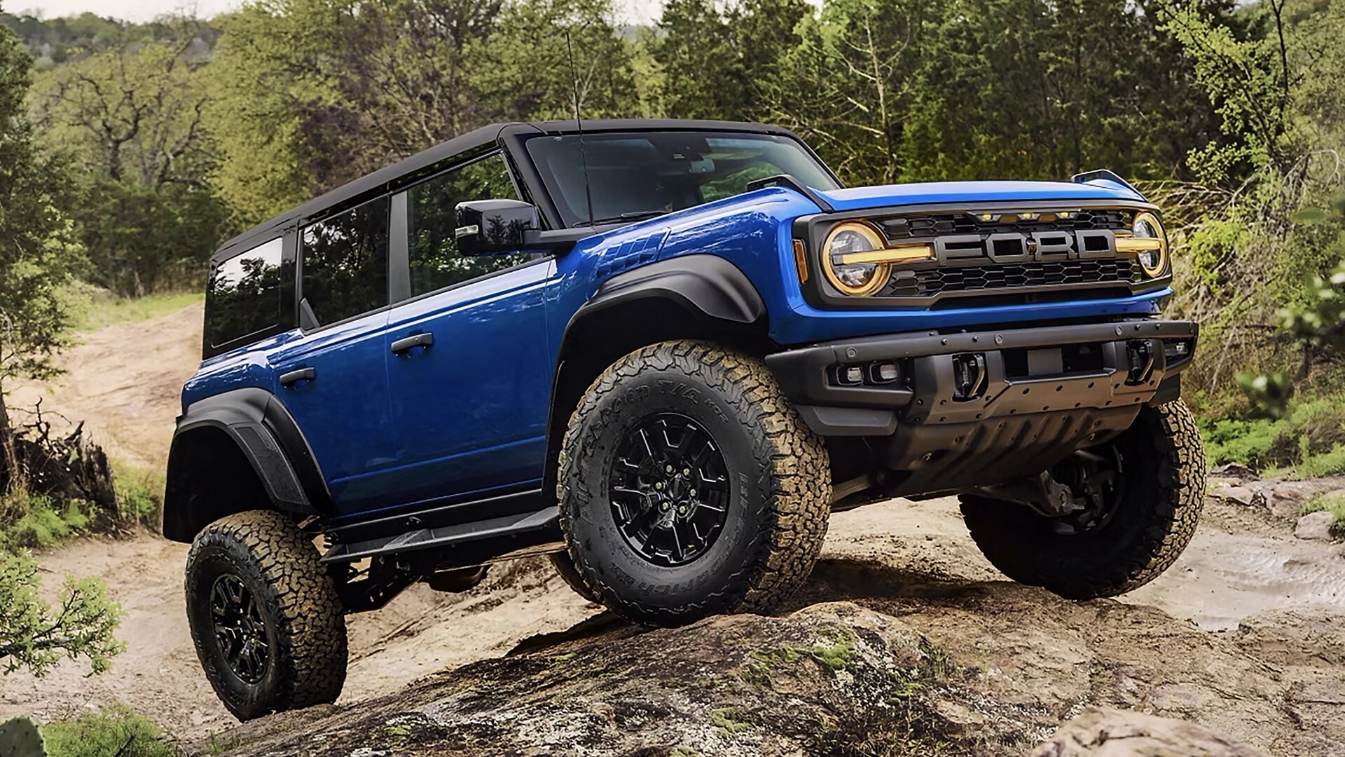 Un VUS Ford Bronco® Raptor® 2025 grimpant une colline boueuse dans la forêt