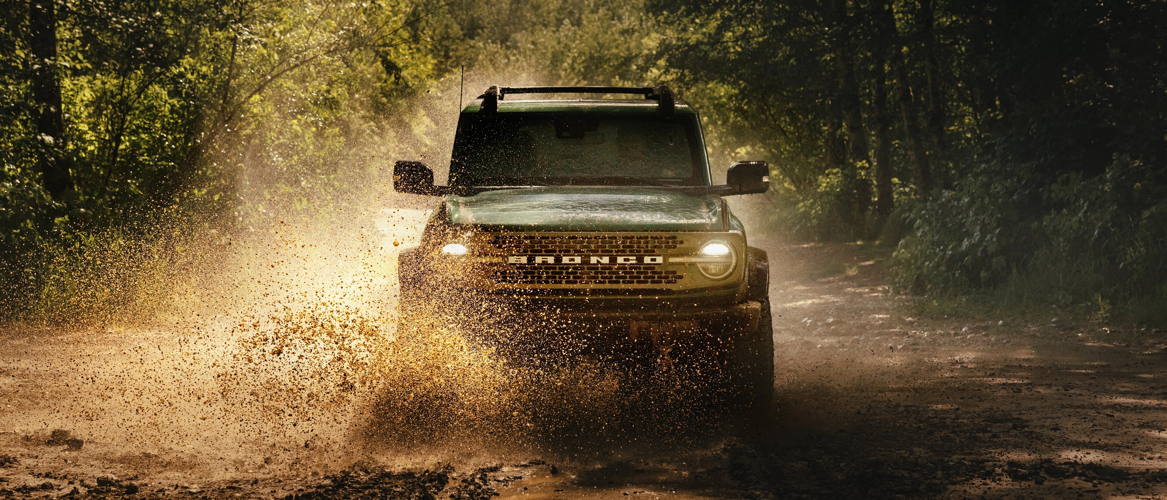 Un VUS Ford Bronco® 2025 franchissant un ruisseau dans les bois
