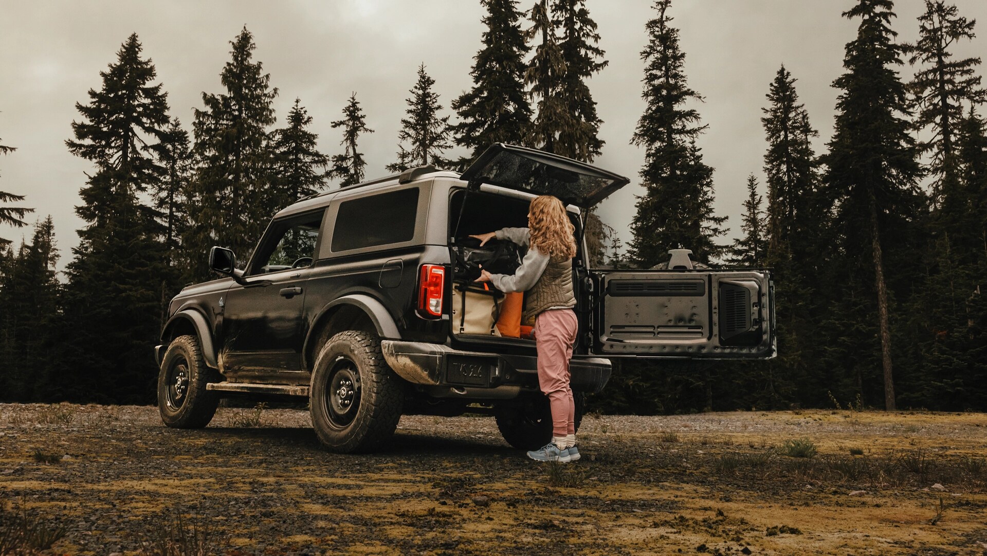 Une femme déchargeant de l’équipement de l’arrière d’un VUS Ford Bronco® 2025 avec le hayon ouvert