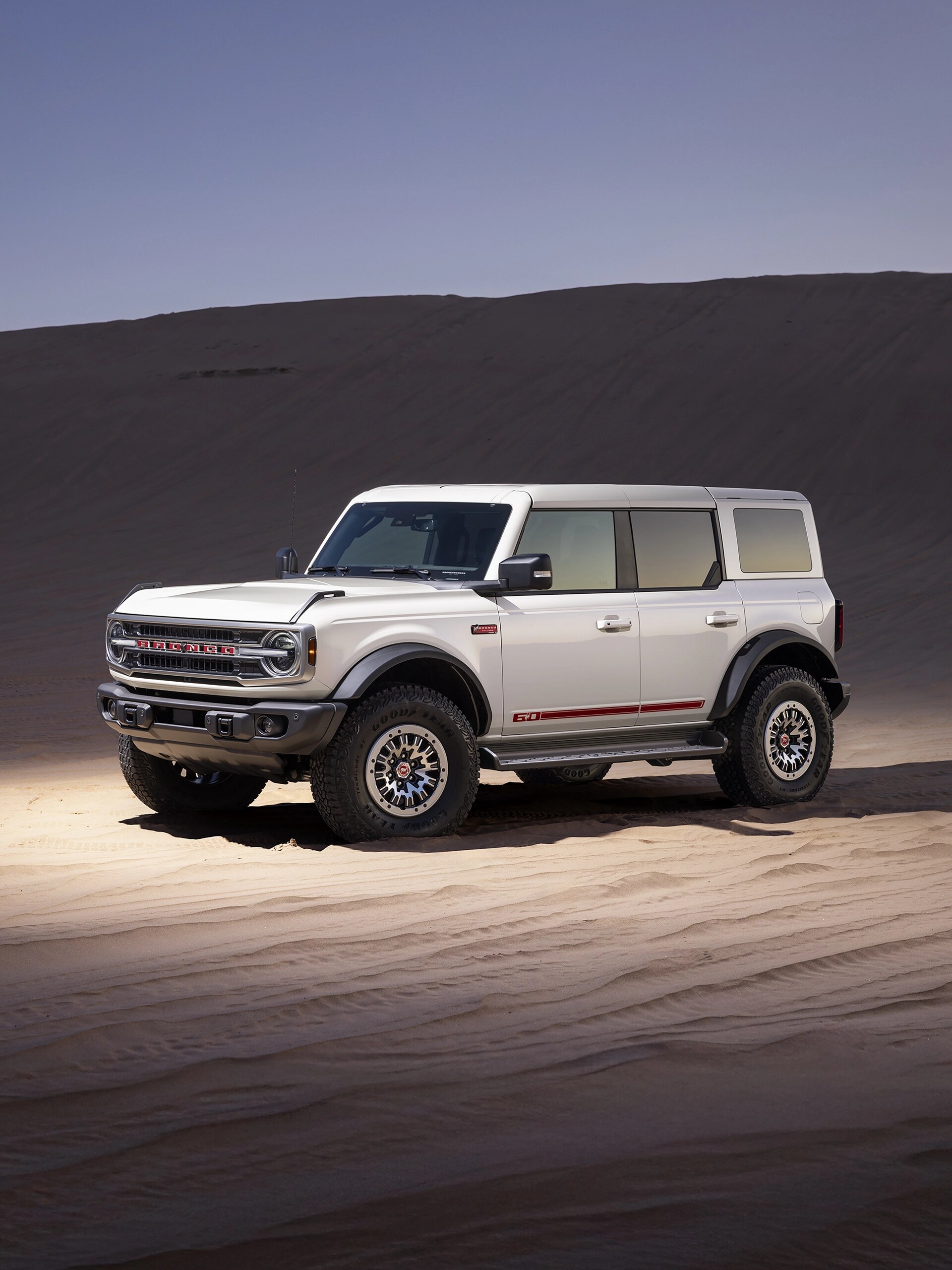 Un VUS Ford Bronco® Outer Banks® 2026 avec le pack 60e anniversaire en option, garé sur une étendue de sable.