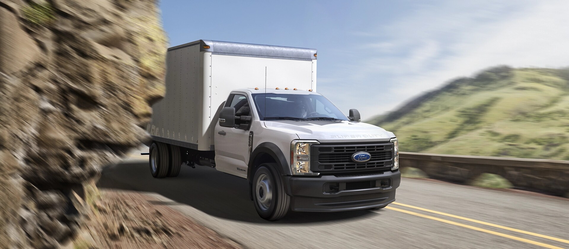 Un Ford Super Duty® à châssis-cabine 2026 avec caisson circulant dans une courbe de montagne serrée