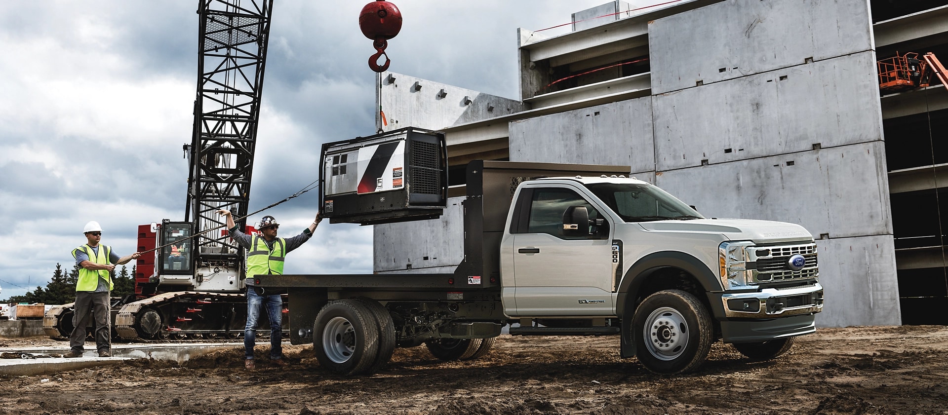 Un Ford Super Duty® à châssis-cabine 2026 stationné sur un chantier de construction alors qu’un objet est chargé sur la plateforme