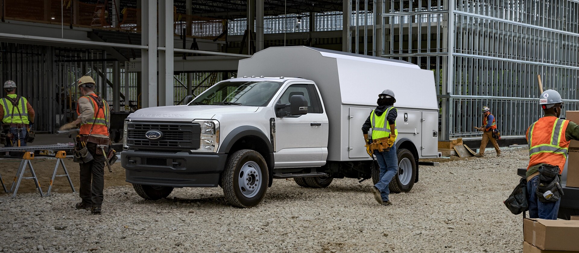 Ouvriers utilisant un Ford Super Duty® à châssis-cabine 2026 équipé d’un coffre utilitaire sur un chantier de construction