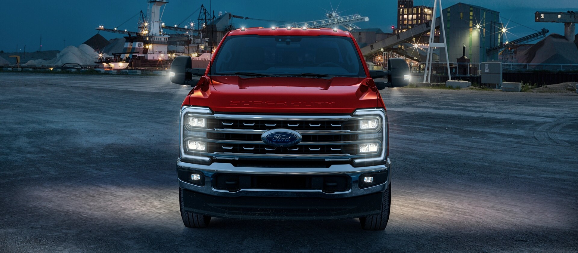 Un Ford Super Duty® 2026 sur un chantier la nuit avec tous ses feux extérieurs allumés