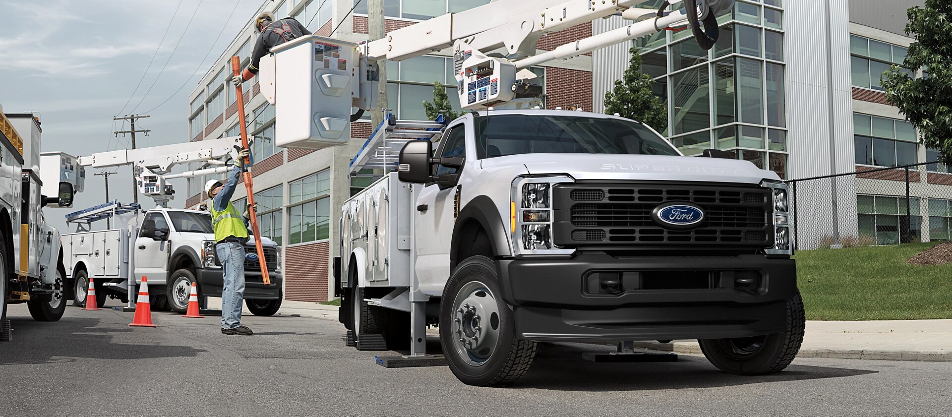 Deux travailleurs utilisant la rallonge de flèche sur un Ford Super Duty® à châssis-cabine 2026 pour réparer un poteau électrique