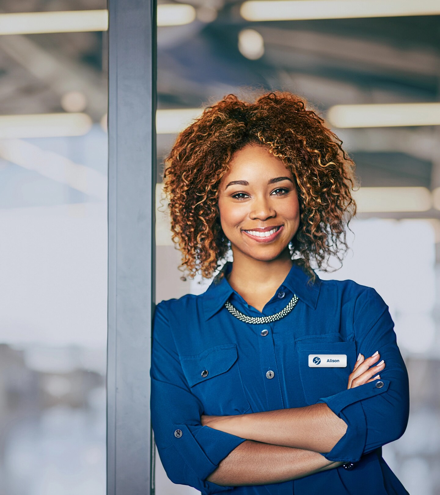Un employé de Ford souriant, vêtu d'une chemise bleue.