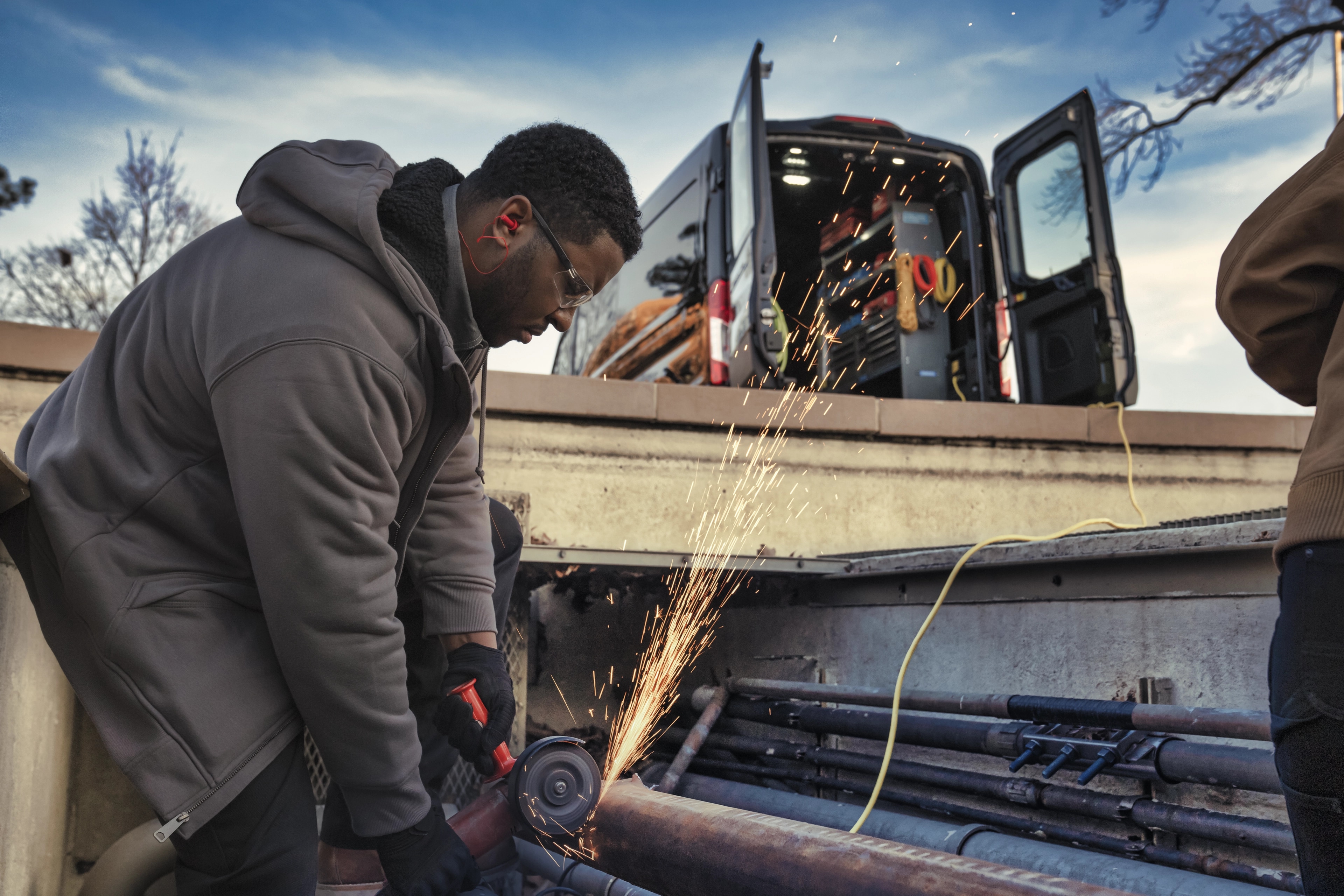 Une fourgonnette Ford E-Transit™ 2025 foncée avec portières arrière ouvertes pour branchement à Pro Power Onboard™