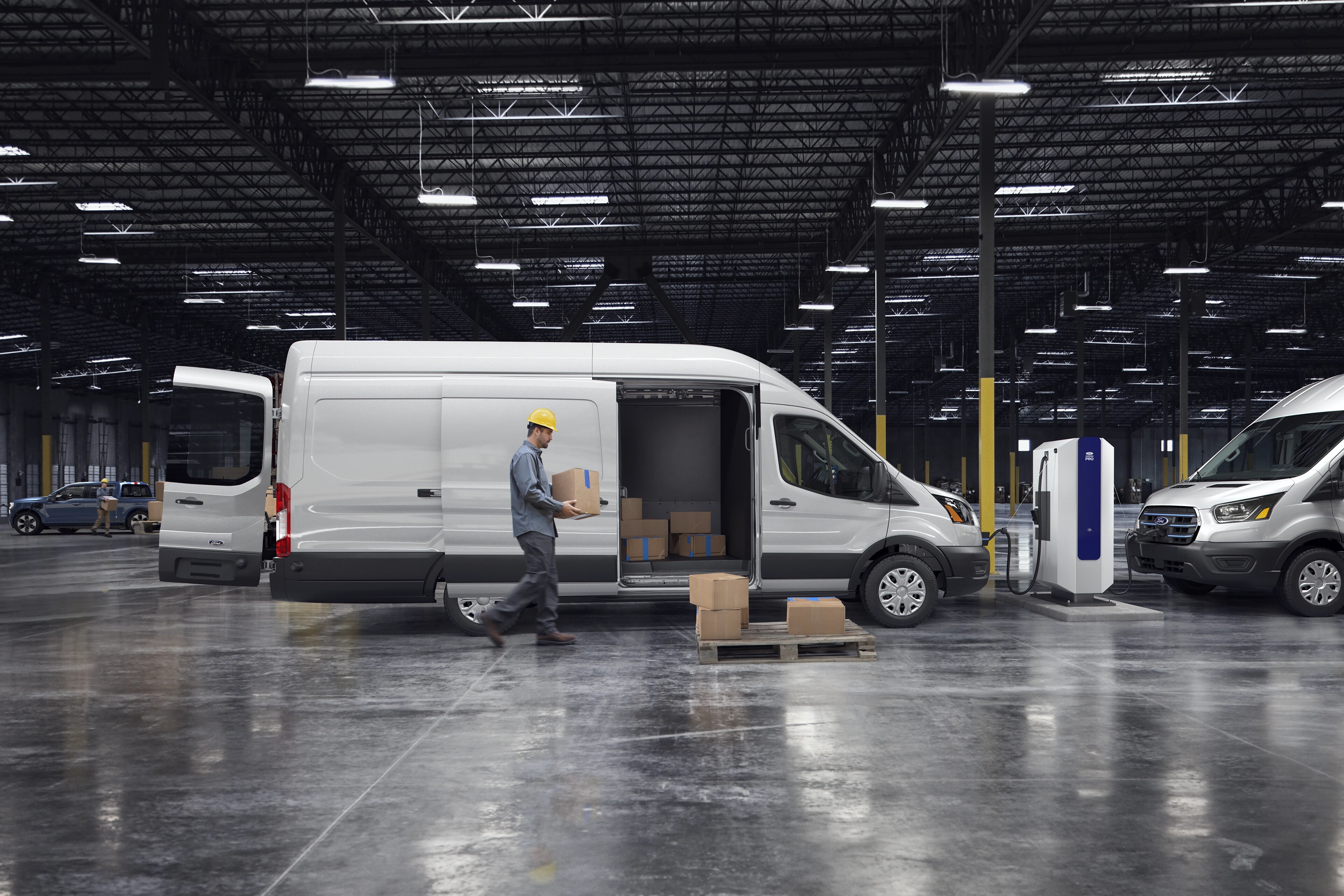Une fourgonnette Ford E-Transit™ 2025 blanche stationnée dans un entrepôt