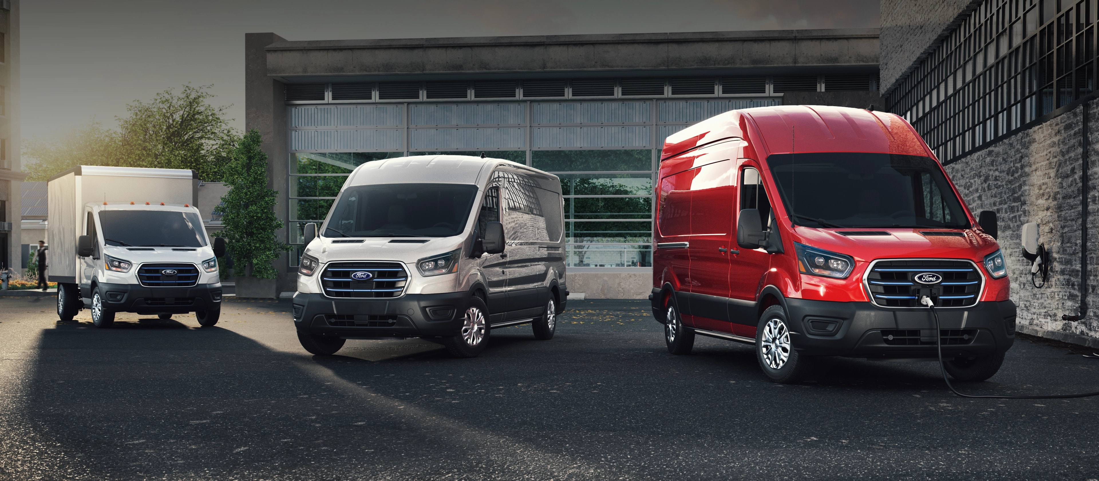 Trois véhicules Ford E-Transit™ 2025 garés dans un stationnement d’entreprise