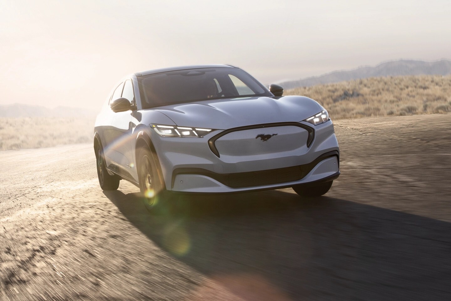 Une Mustang Mach-E® blanche roule sur une route