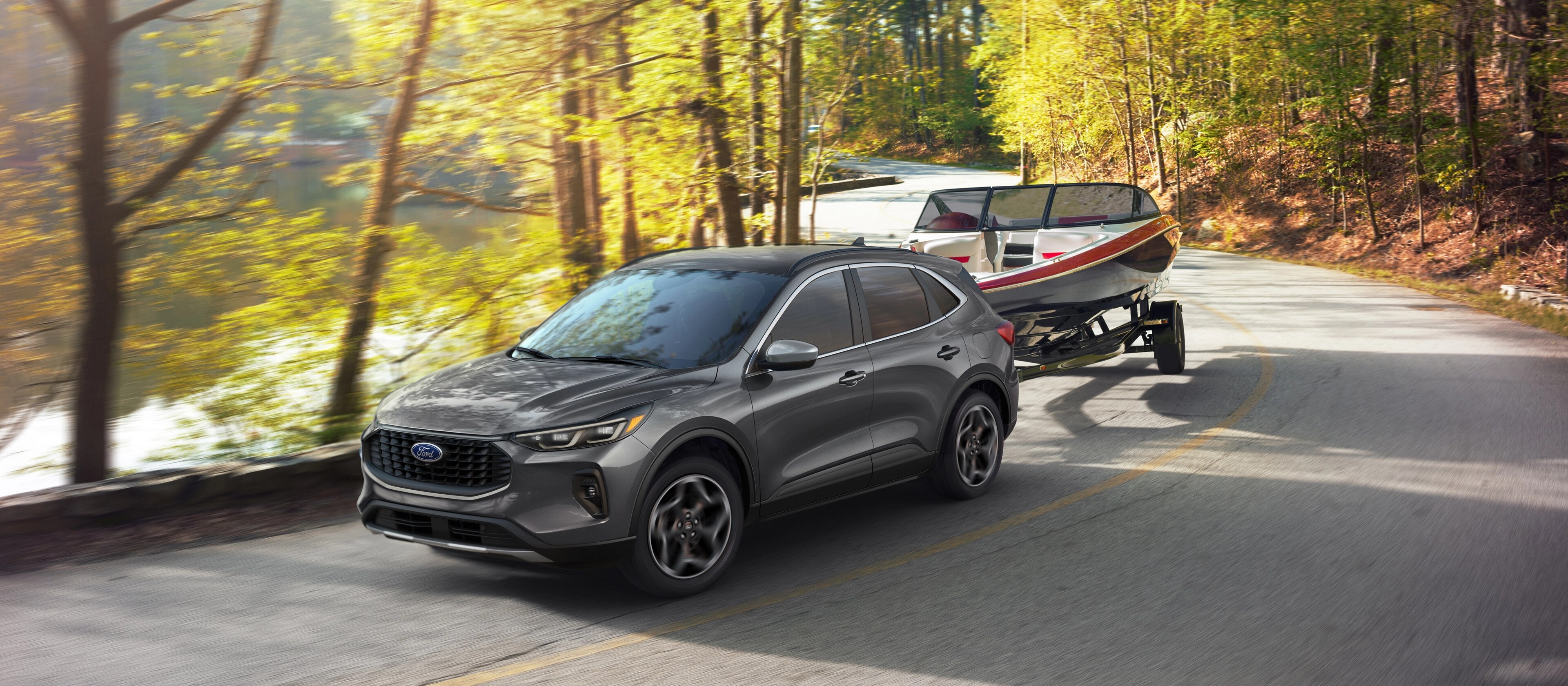 Le VUS Ford Escape® 2026 remorquant un petit bateau sur une route de lac