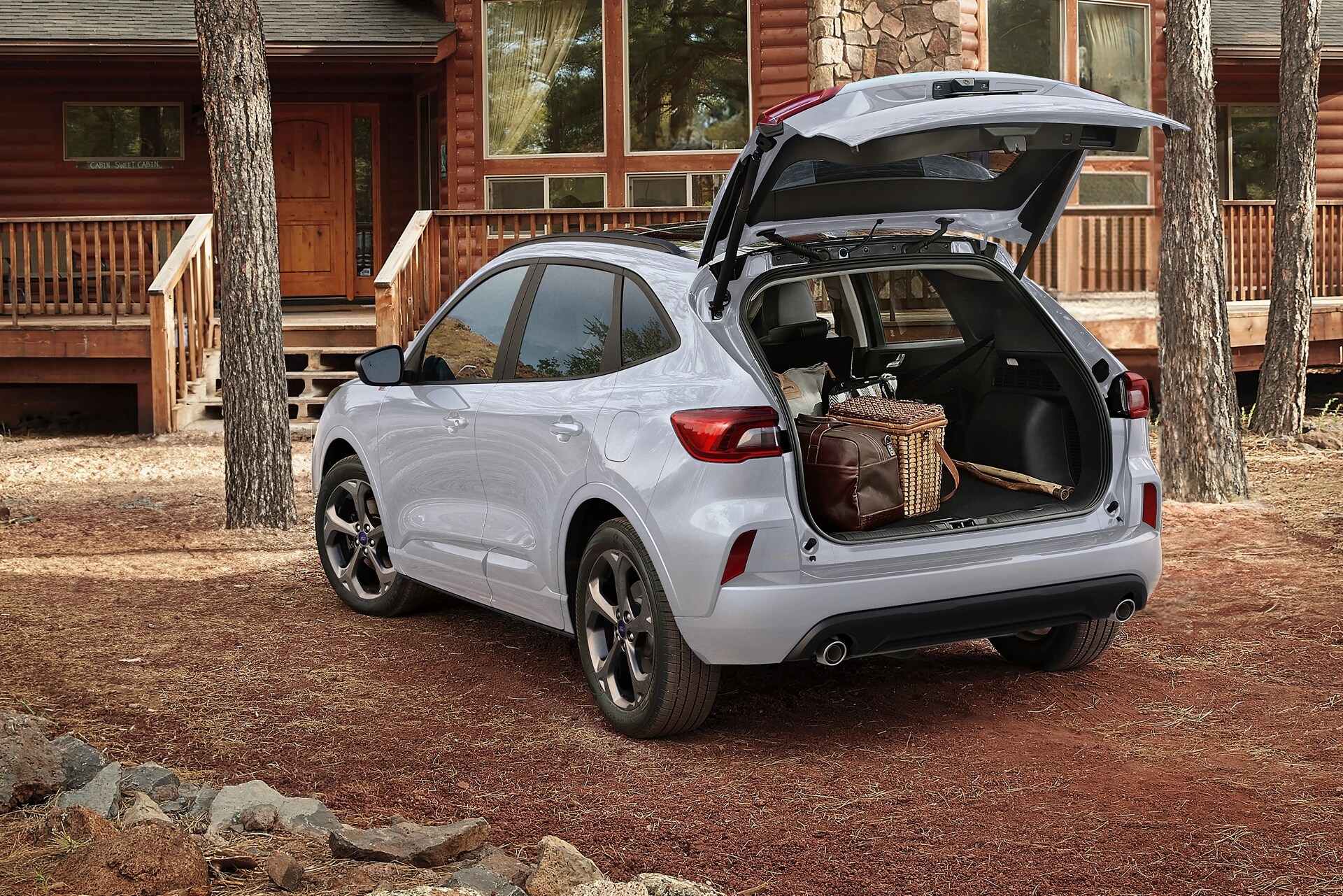 VUS Ford Escape® 2026 stationné devant un chalet avec le hayon électrique ouvert