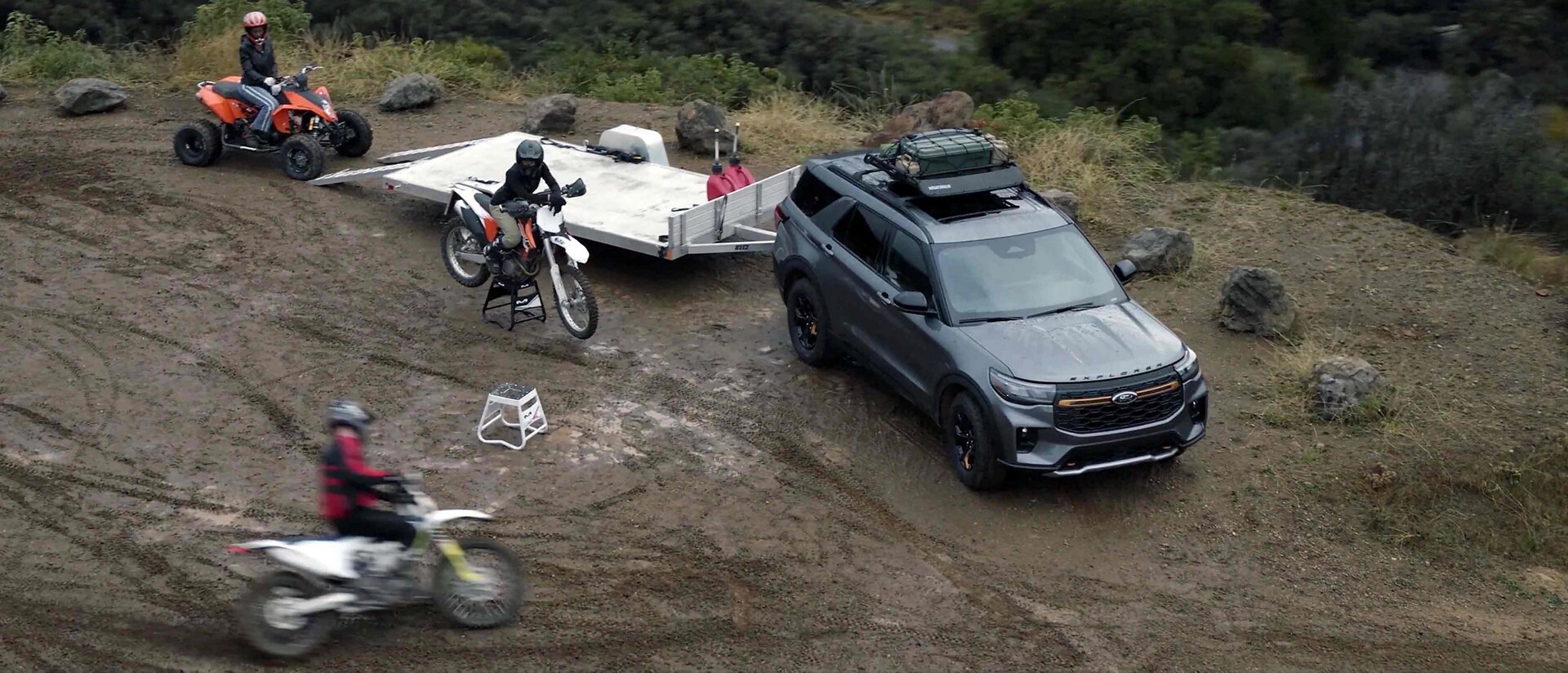 Des personnes utilisant des motos tout-terrain et un VTT près d'un VUS Ford Explorer® Tremor® 2026