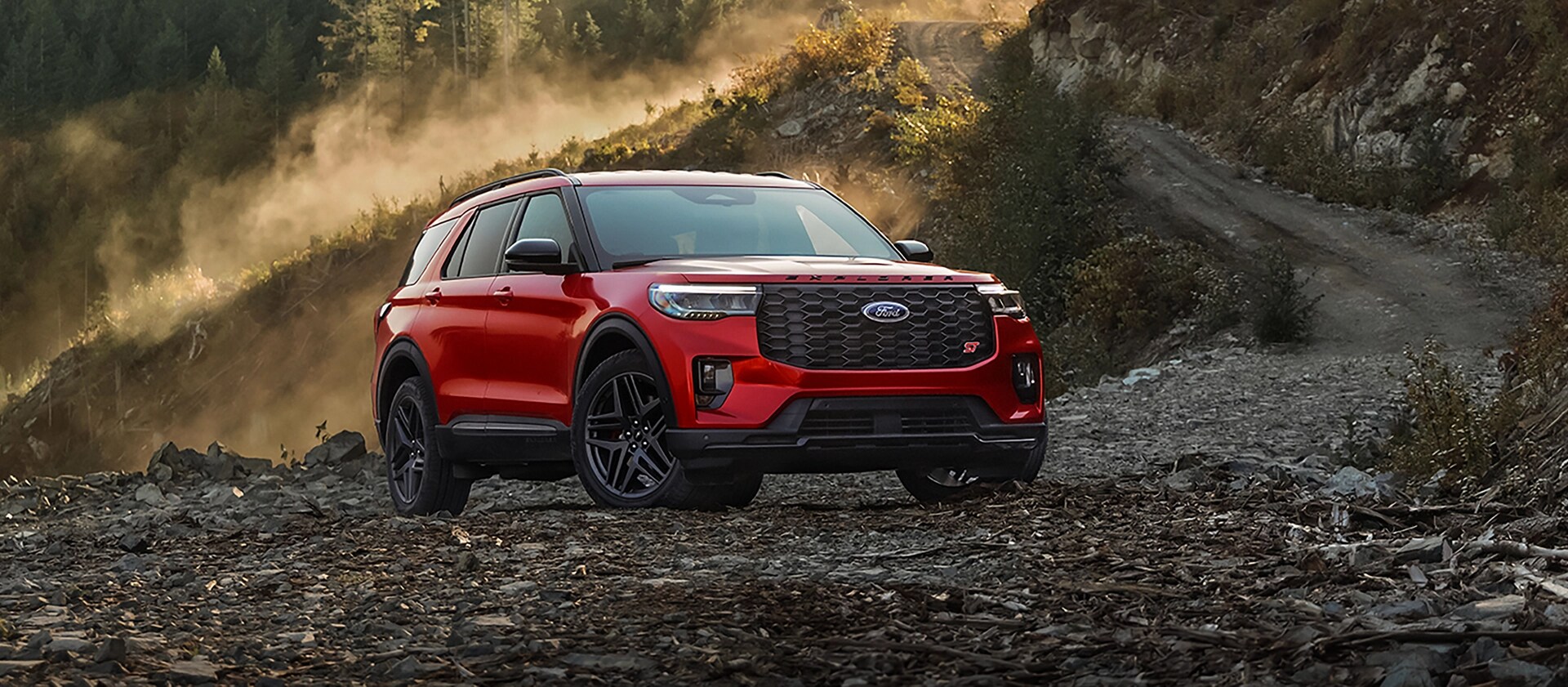 Un VUS Ford Explorer® ST 2026 stationné sur une étendue rocheuse, près d’une montagne