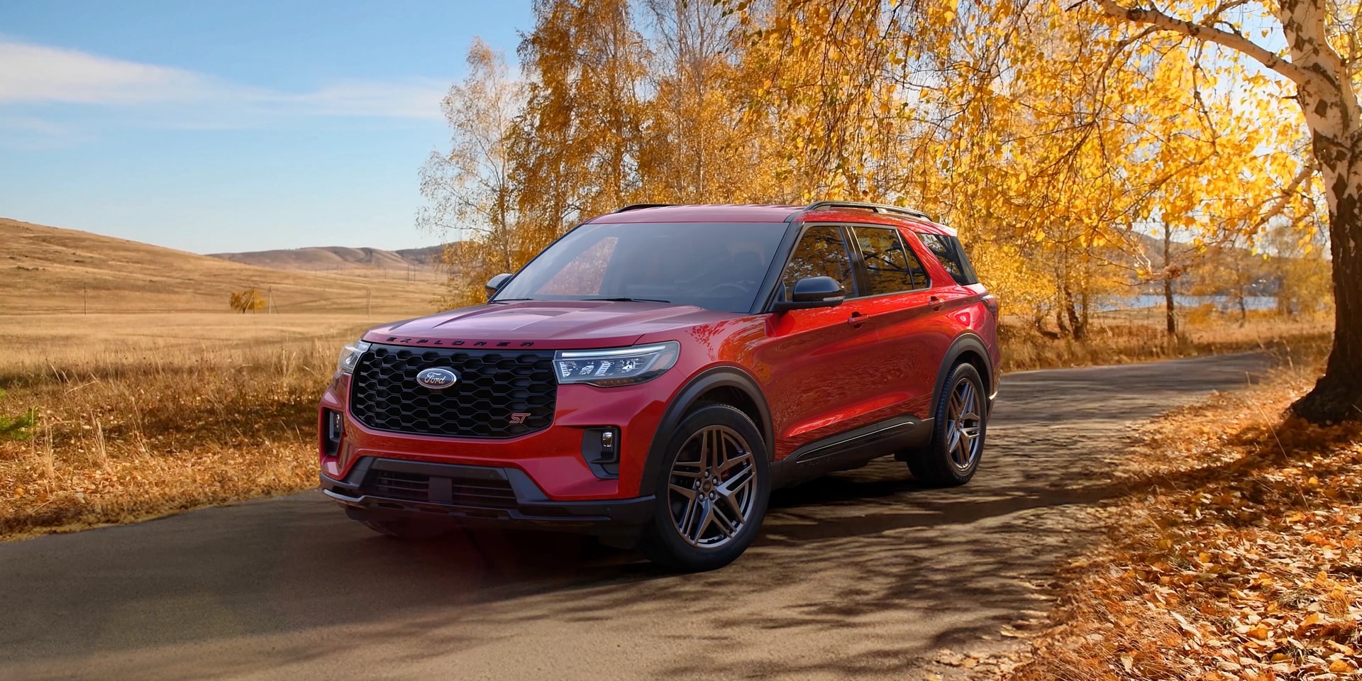 Un VUS Ford Explorer® 2026 sur une route à côté d’un champ à l’automne