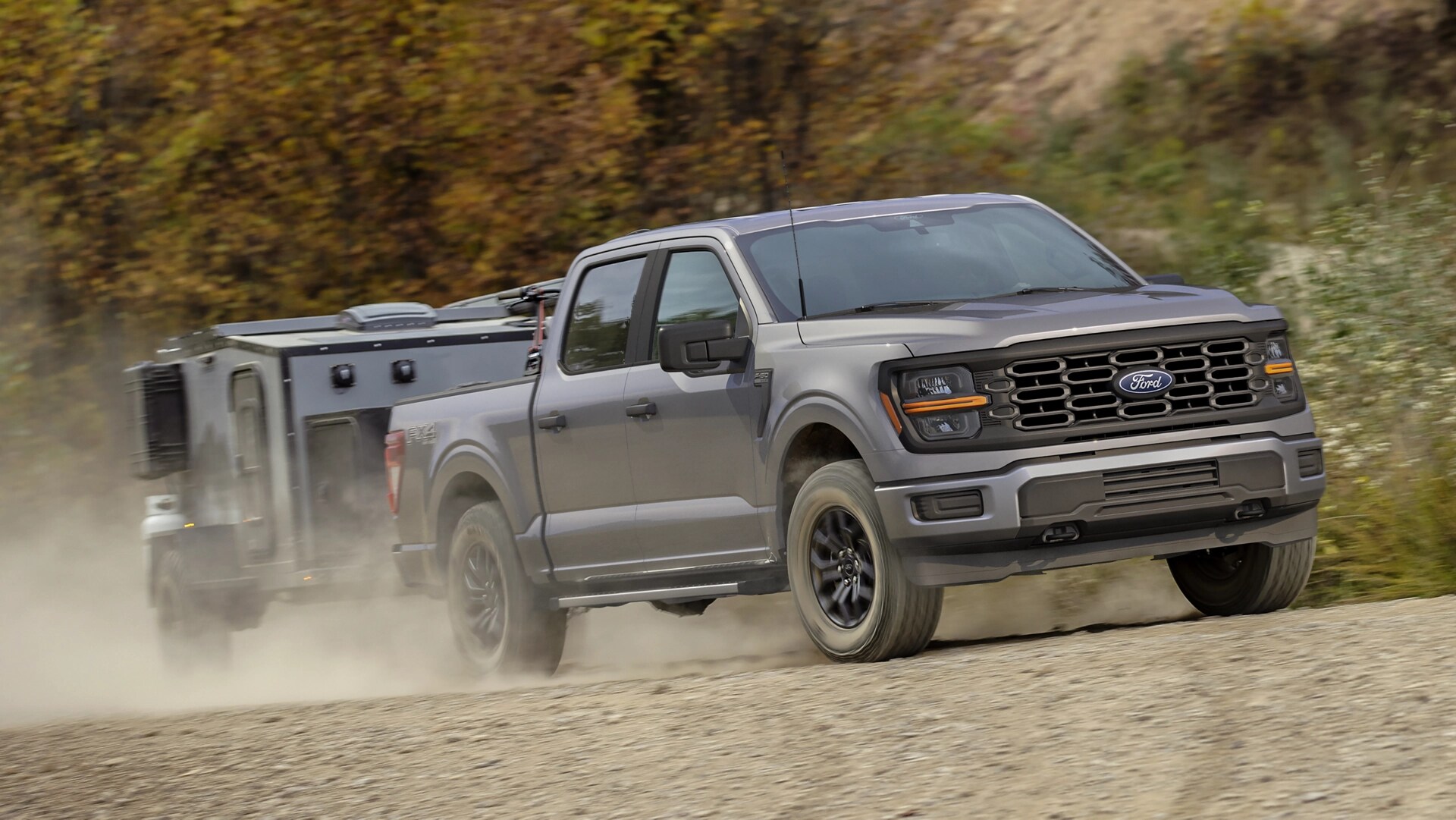 Modèle Ford F-150® FX4® 2025 tirant un petite roulotte sur une route de terre