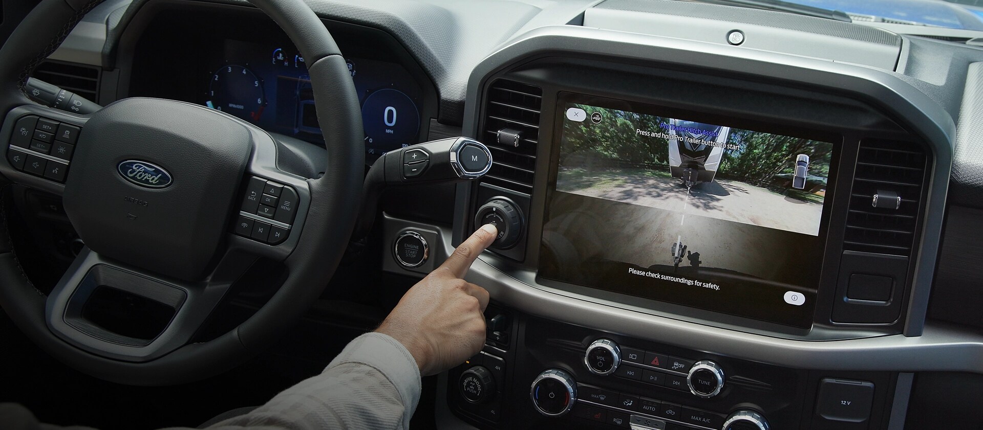 Une personne active le Pro Trailer Hitch Assist™ à l’aide du bouton Pro Trailer à l’intérieur d’un camion Ford F-150® 2025