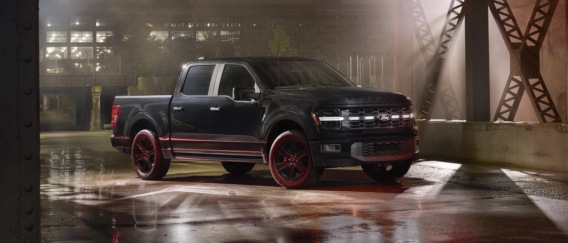 Un Ford F-150® STX 2025 noir avec l’ensemble Lobo™, stationné dans une rue vacante de la ville la nuit