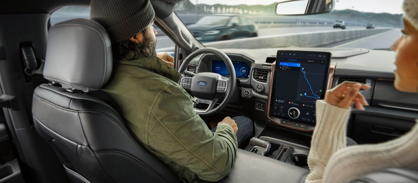 Deux personnes dans un Ford F-150® Lightning® 2025 circulant sur l’autoroute, utilisant la fonction BlueCruise