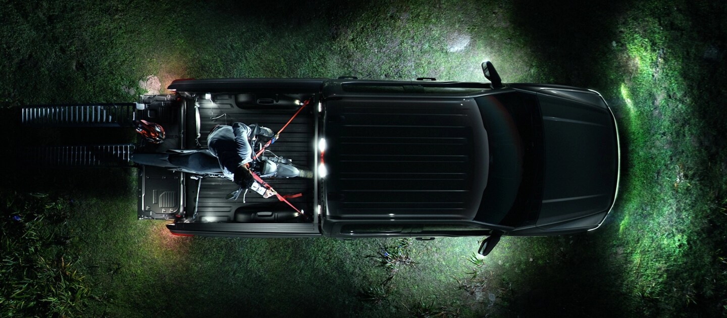 Vue aérienne d’un camion Ford F-150® Lightning® 2025 avec l’éclairage de zone à DEL qui éclaire la zone alentour