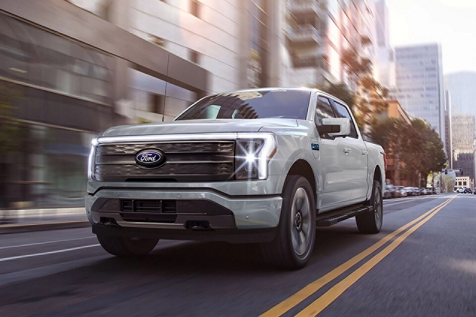 Une camionnette Ford F-150® Lightning® 2025 circulant dans une rue de la ville