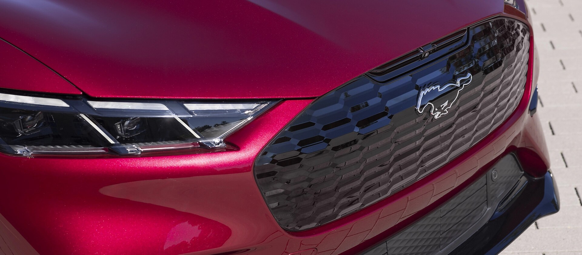 Gros plan de la calandre et de l’insigne de poney sur la Ford Mustang Mach-E® 2025