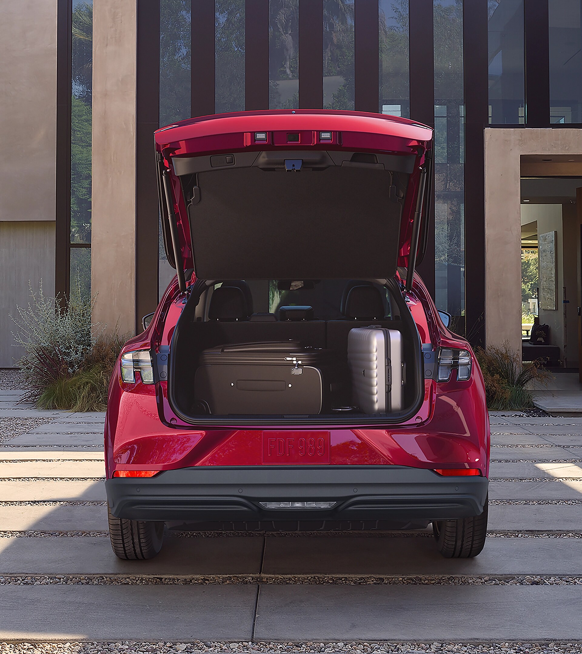 Espace de chargement d’une Ford Mustang Mach-E® 2025 stationnée dans l’entrée d’une maison de luxe