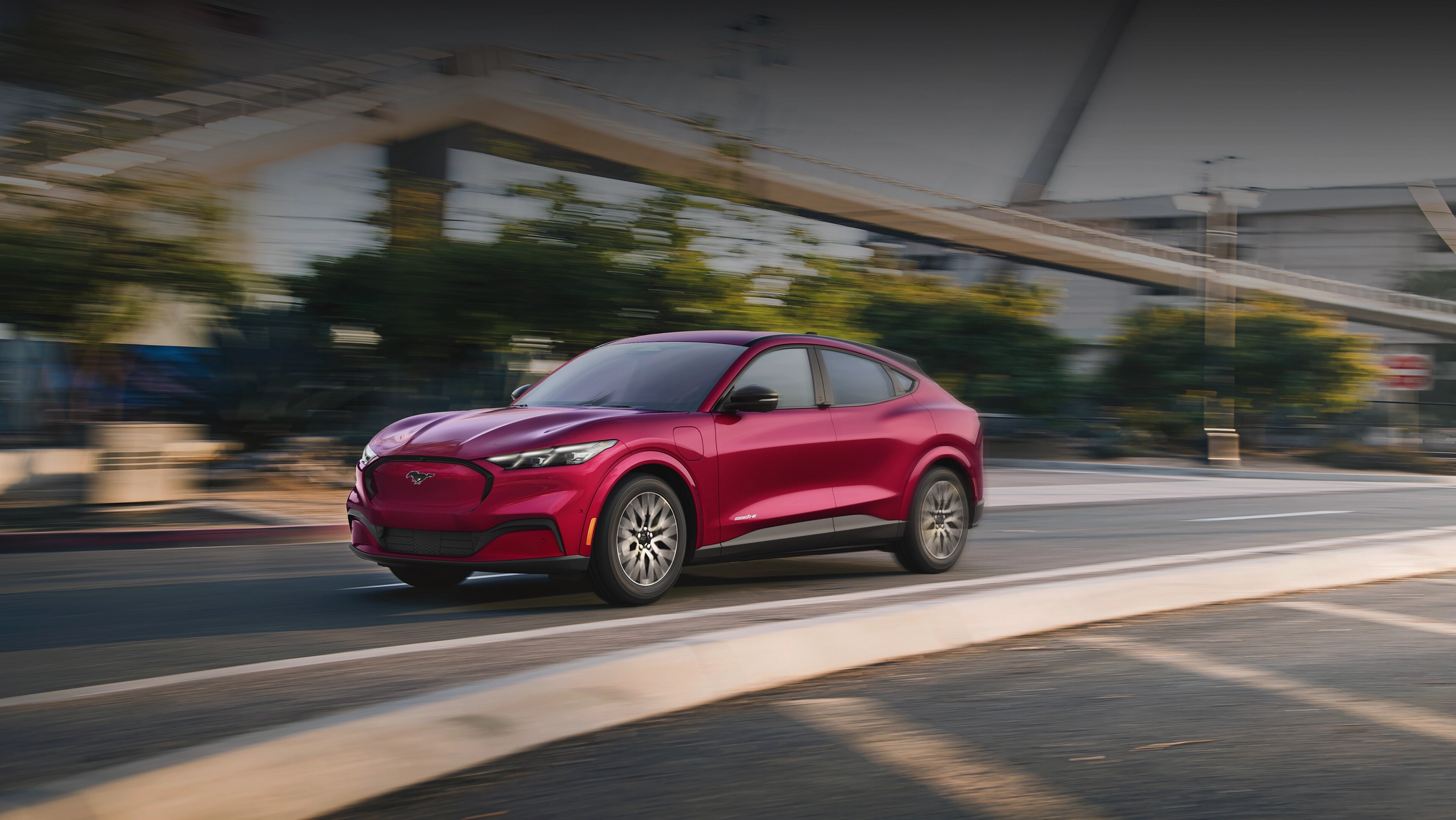 Ford Mustang Mach-E® 2025 circulant dans une rue de la ville