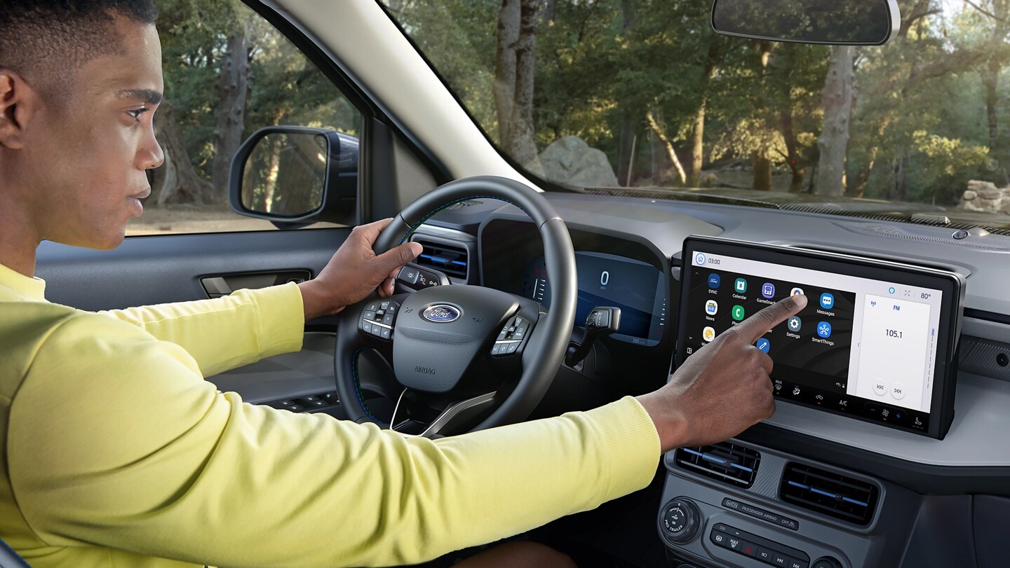 Un conducteur utilisant l’écran tactile sur une camionnette Ford Maverick® 2025 stationnée