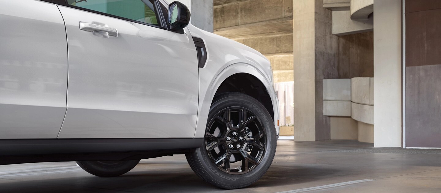 Une camionnette Ford Maverick® 2025 stationnée devant une structure en béton moderne