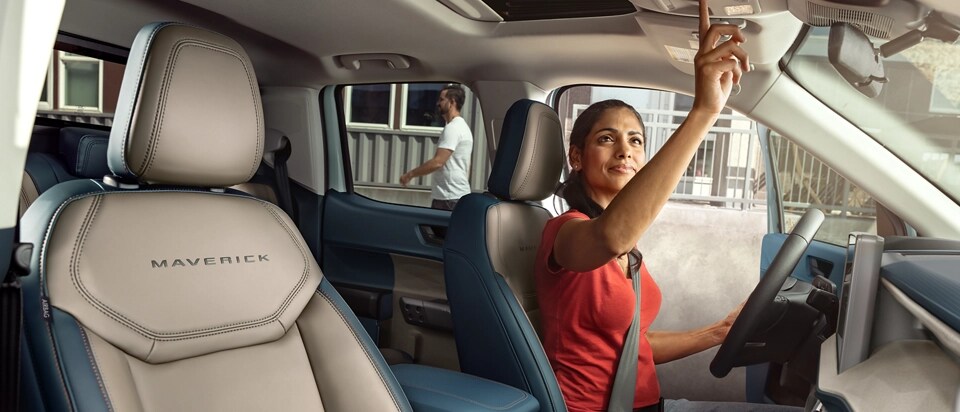 Une femme utilisant le toit ouvrant électrique sur une camionnette Ford Maverick® Lariat® 2025