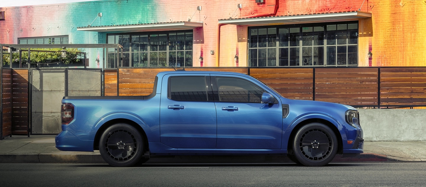 Un Ford Maverick® Lobo 2025 bleu stationné devant un restaurant coloré