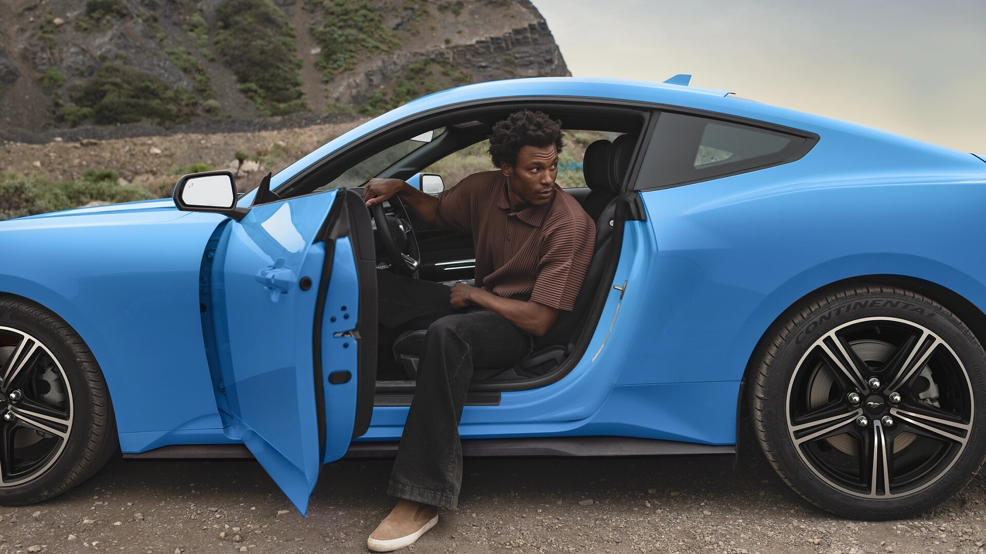 Personne sortant d’une Ford Mustang® Coupé 2025 stationnée dans le désert