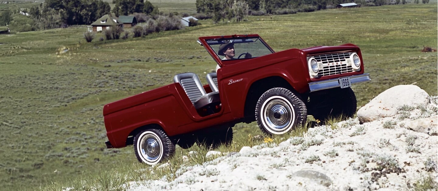Bronco Roadster des années 1960 gravissant une côte.