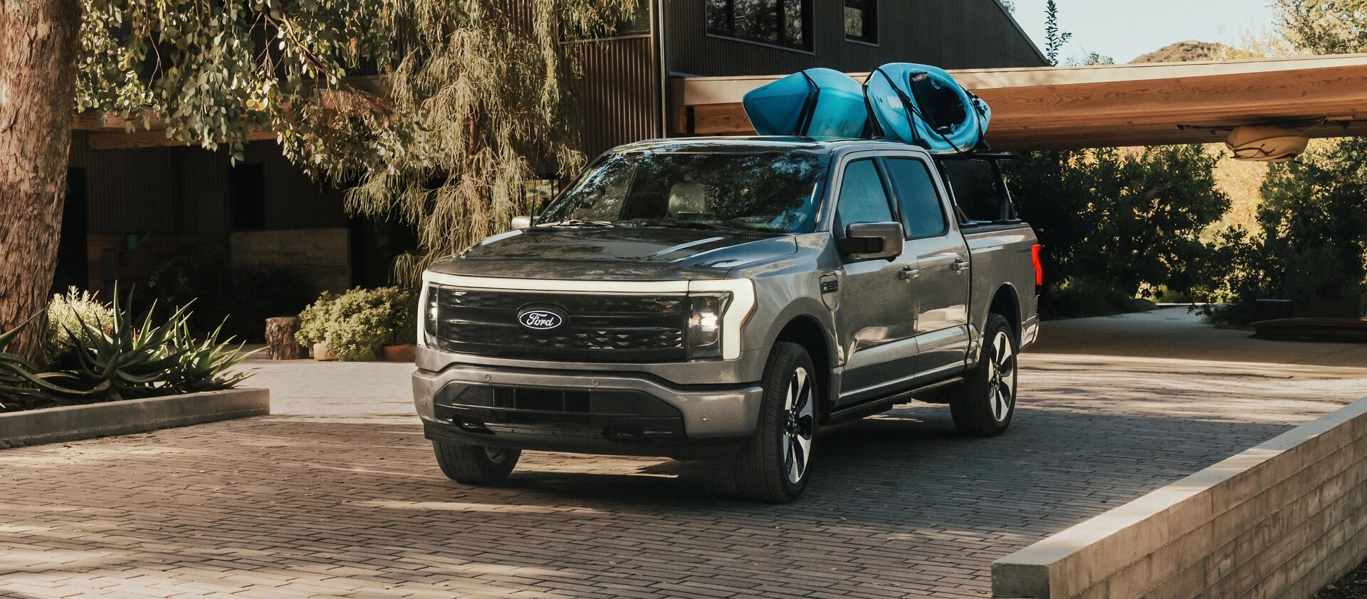 Un F-150 Lightning avec des kayaks attachés à un porte-bagages monté à l'arrière.