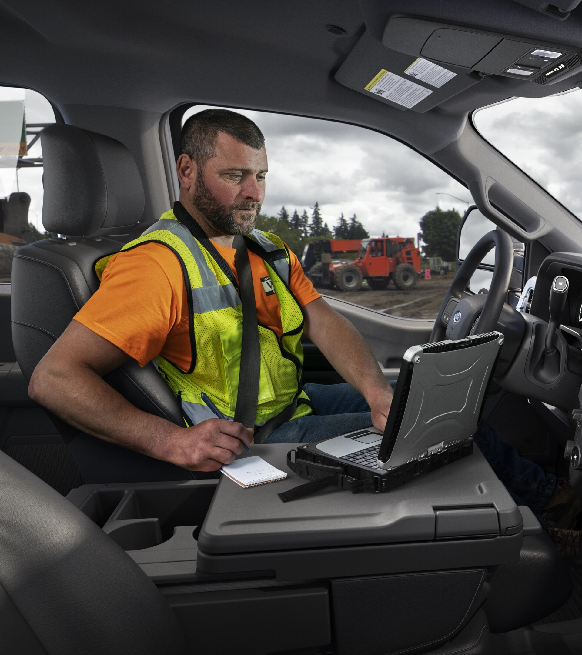 Une personne utilisant un ordinateur portable avec la surface de travail intérieure à l’intérieur de l’habitacle de son modèle Ford Super Duty® F-250® XL 2026