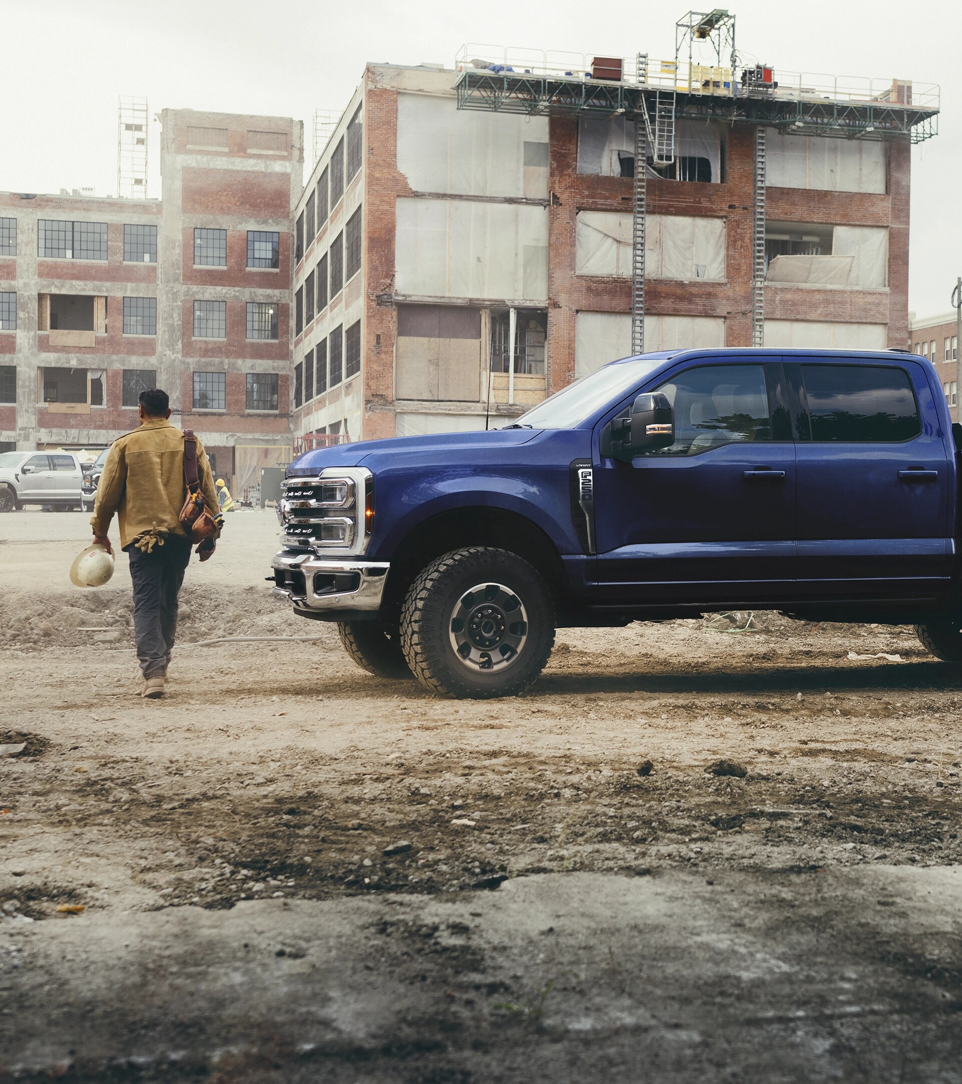 Une personne s’éloignant de son Ford Super Duty® F-250® Lariat® 2026 en bleu argon sur un chantier de construction